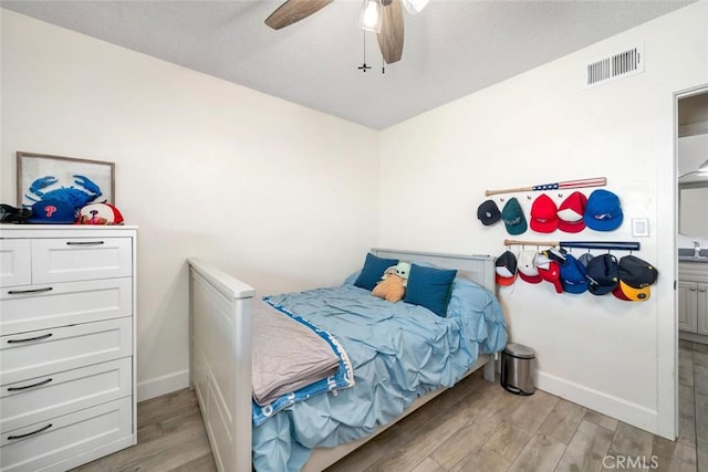 bedroom with visible vents, light wood-style flooring, and baseboards