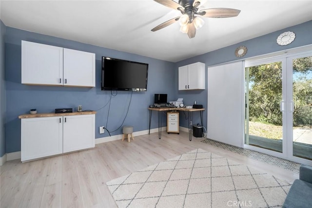 office space with light wood-type flooring, a wealth of natural light, ceiling fan, and baseboards