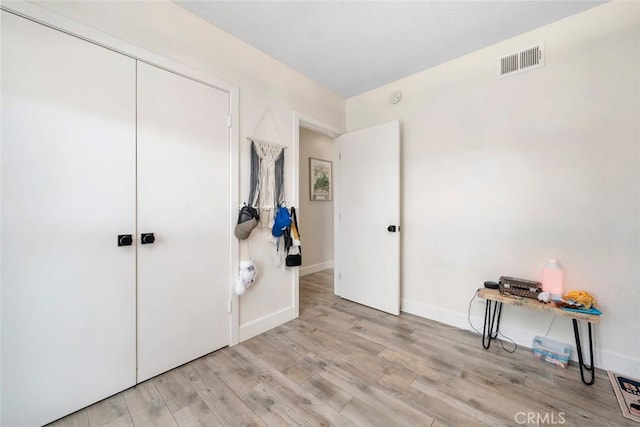 interior space with light wood finished floors, baseboards, and visible vents
