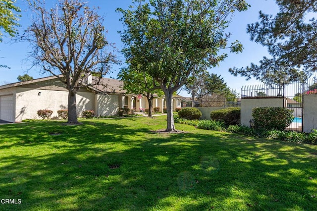 view of yard featuring a garage and fence