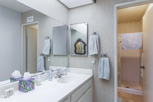 bathroom with a stall shower, visible vents, vanity, and tile patterned floors