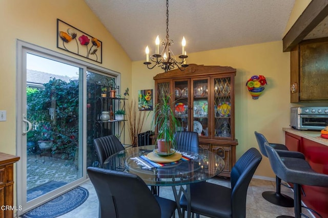 dining area with a chandelier, lofted ceiling, a toaster, and a textured ceiling