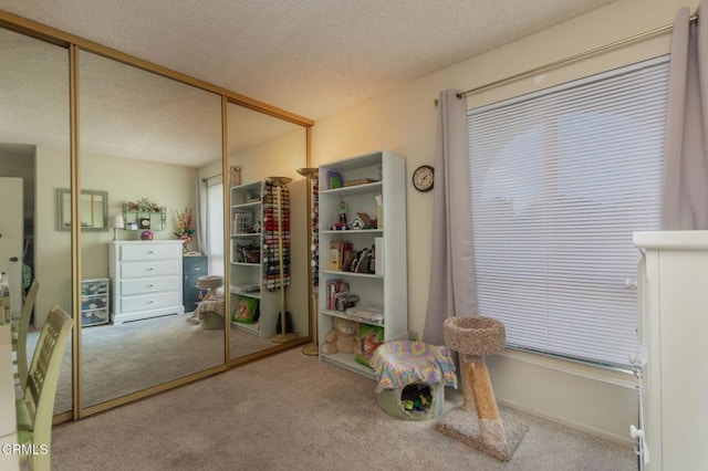 interior space featuring a textured ceiling, a closet, and carpet flooring