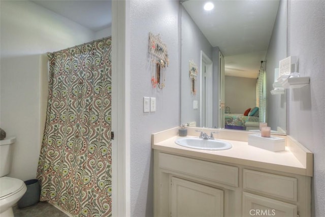 ensuite bathroom featuring ensuite bathroom, a shower with shower curtain, vanity, and toilet