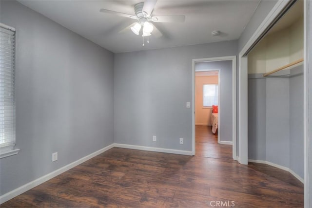 unfurnished bedroom featuring a ceiling fan, a closet, baseboards, and dark wood-type flooring