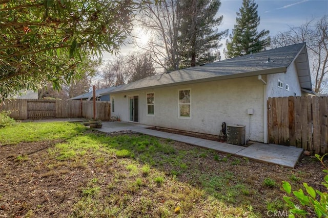 rear view of property with a patio area, a yard, fence, and stucco siding