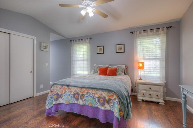 bedroom with a closet, baseboards, vaulted ceiling, and wood finished floors