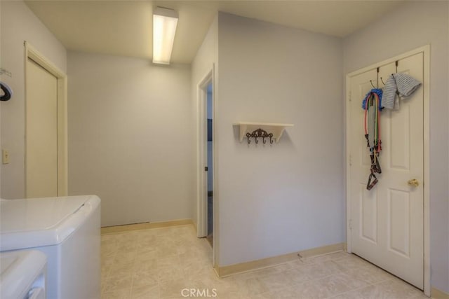 clothes washing area featuring laundry area, baseboards, and washer and dryer