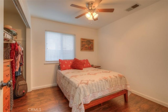 bedroom with visible vents, ceiling fan, baseboards, and wood finished floors