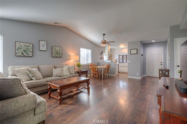 living room with dark wood-style flooring, visible vents, vaulted ceiling, ceiling fan, and baseboards