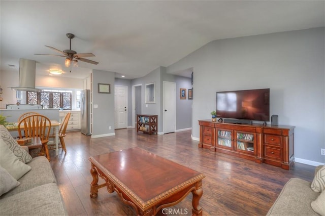 living room with lofted ceiling, ceiling fan, baseboards, and wood finished floors