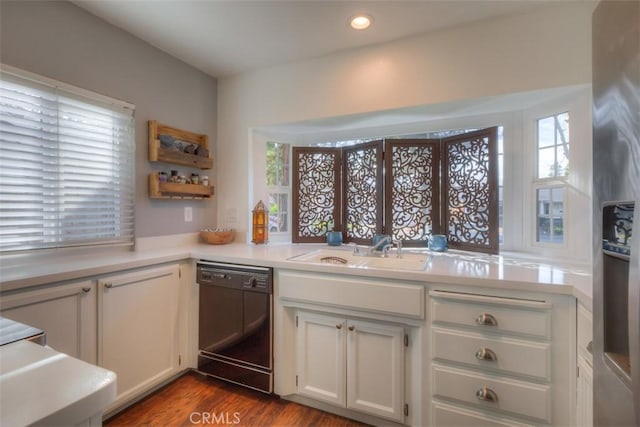 kitchen with dark wood finished floors, white cabinets, dishwasher, light countertops, and a sink