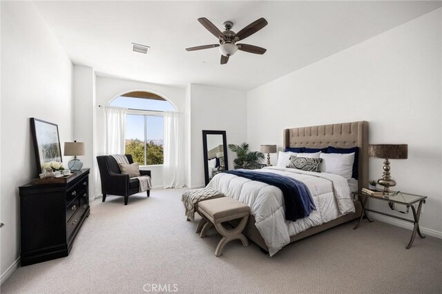 bedroom featuring light carpet, baseboards, visible vents, and a ceiling fan