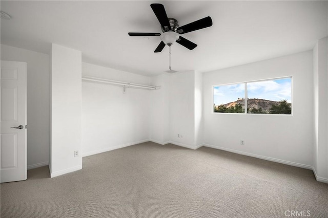 unfurnished bedroom with ceiling fan, carpet, and baseboards