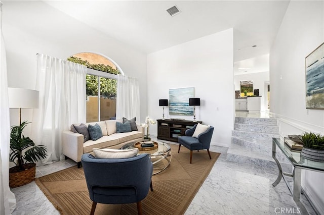 living area featuring marble finish floor and visible vents