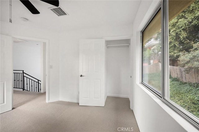 unfurnished bedroom with carpet, visible vents, ceiling fan, and baseboards