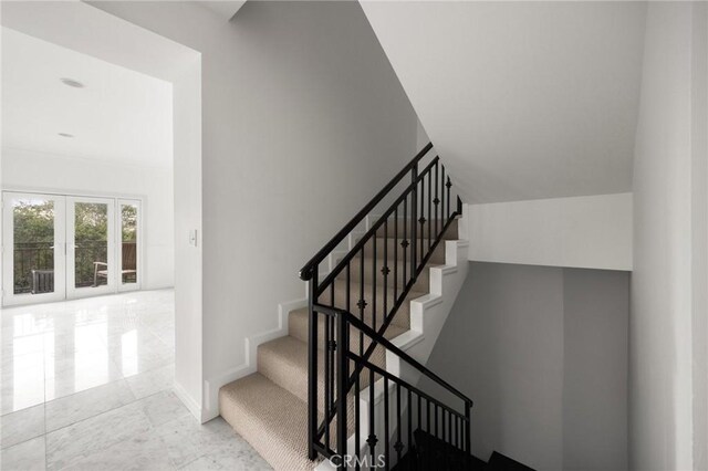 stairway with baseboards and french doors