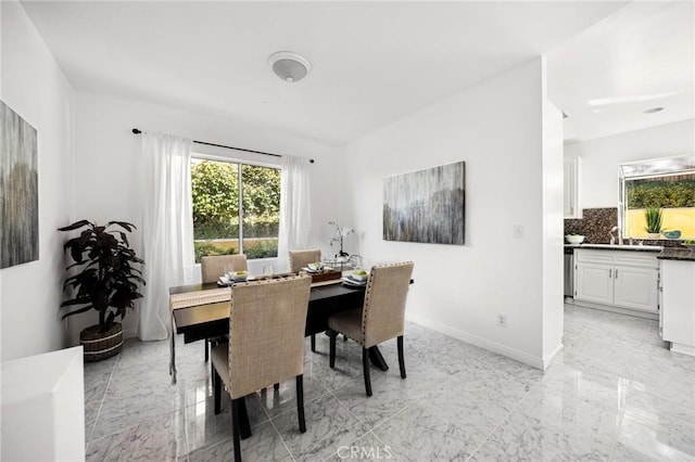 dining space featuring marble finish floor and baseboards