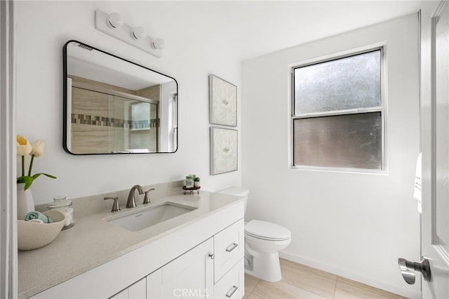 bathroom featuring toilet, a stall shower, and vanity