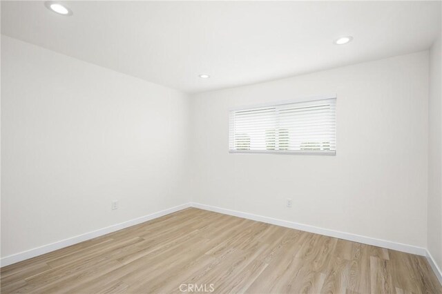 empty room featuring light wood-style floors, baseboards, and recessed lighting