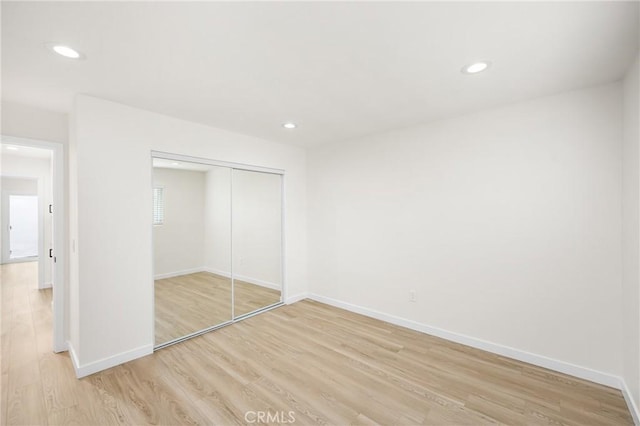 unfurnished bedroom with light wood-style flooring, baseboards, and recessed lighting