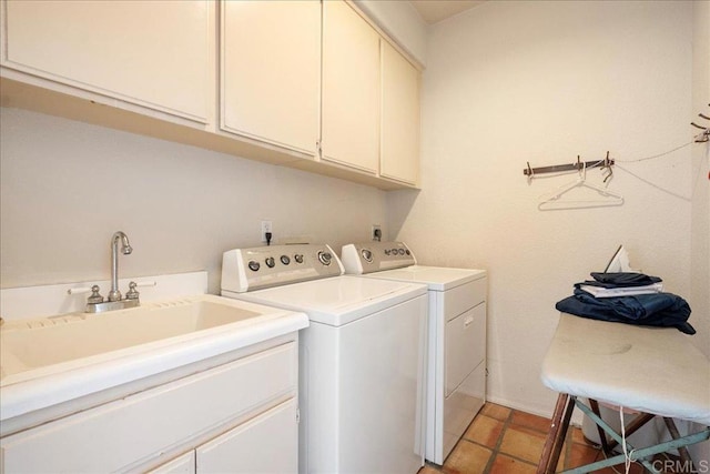 clothes washing area featuring cabinet space, washing machine and dryer, and a sink