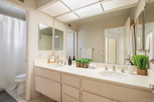 full bath with double vanity, visible vents, toilet, tile patterned flooring, and a sink