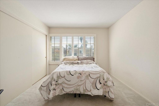 bedroom featuring a closet, carpet flooring, and baseboards