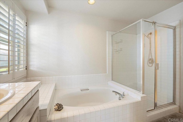 bathroom featuring a stall shower, vanity, and a bath