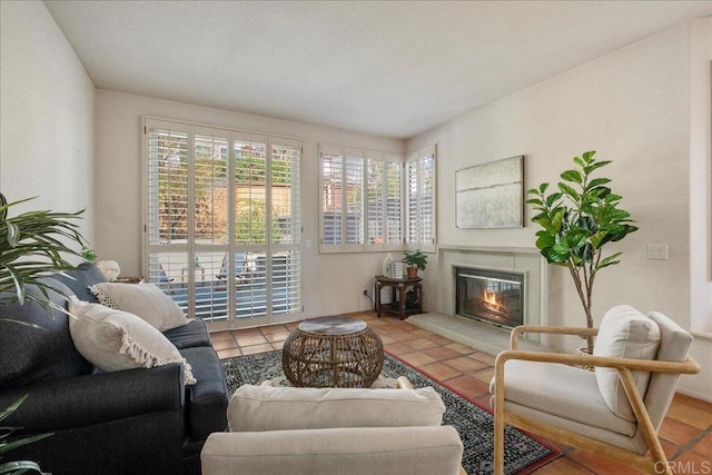 living area featuring tile patterned flooring and a glass covered fireplace