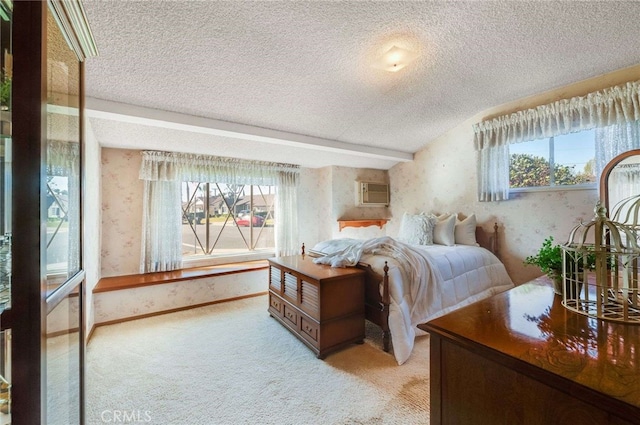 bedroom with wallpapered walls, light colored carpet, baseboards, and a textured ceiling