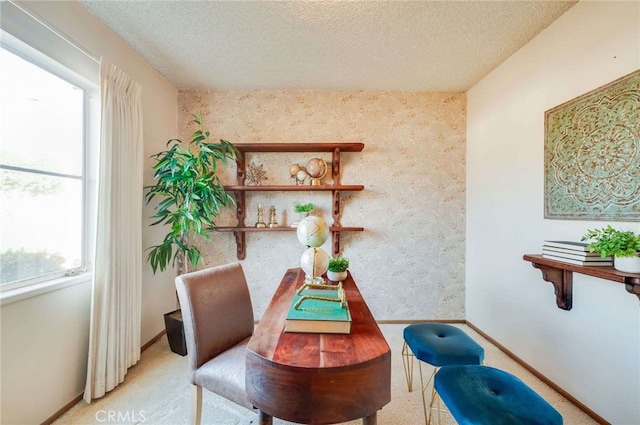 sitting room with a textured ceiling, wallpapered walls, and carpet