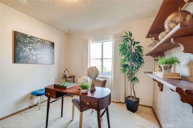 office area featuring baseboards, light colored carpet, and a textured ceiling