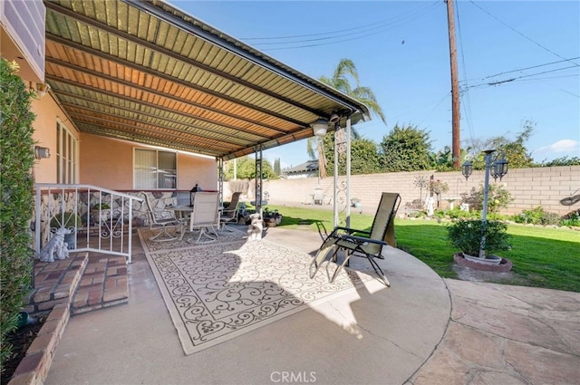 view of patio with outdoor dining area and fence