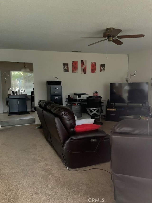 living room with a textured ceiling, carpet, and a ceiling fan