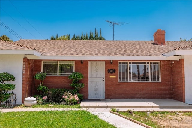 3667 Ada Ct, Riverside, CA 92505 - view of front of home with brick siding, a chimney, and a shingled roof
