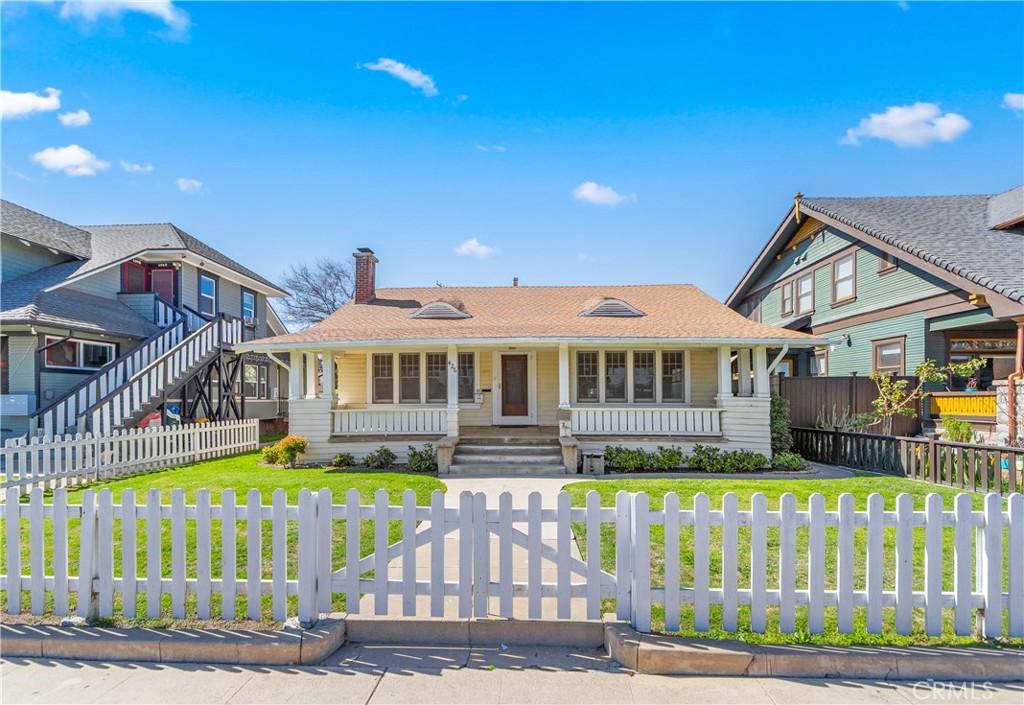 426 S Broadway, Santa Ana, CA 92701 - view of front of home with a porch, a front yard, a chimney, and a fenced front yard