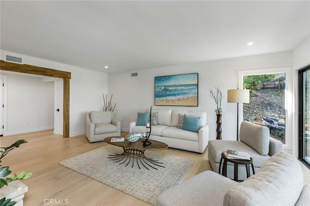 living room with baseboards, wood finished floors, visible vents, and recessed lighting