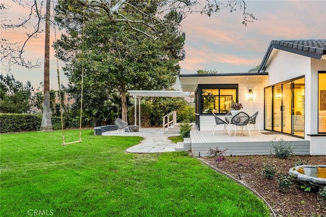 back of property featuring a lawn and a wooden deck