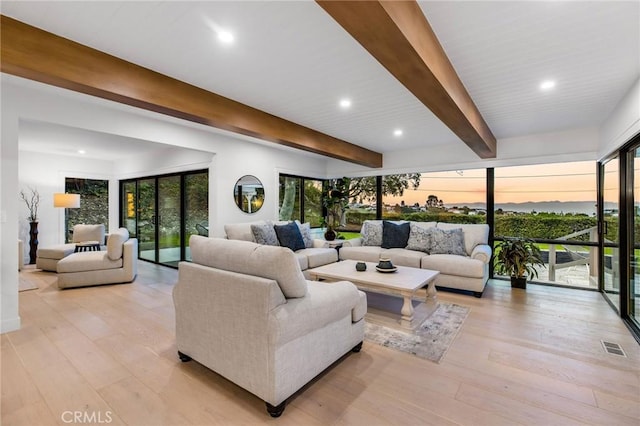 living area with beamed ceiling, recessed lighting, visible vents, and light wood-style floors