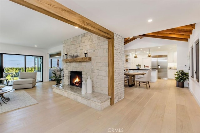 living area with vaulted ceiling with beams, a fireplace, light wood-style flooring, and recessed lighting