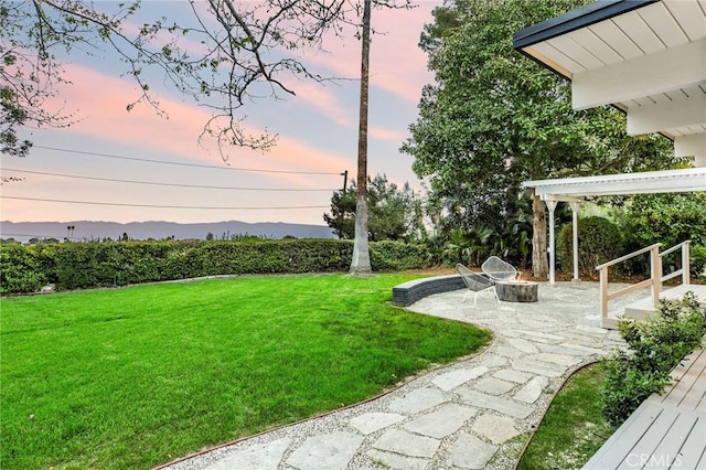 view of yard with a fire pit, a mountain view, and a patio