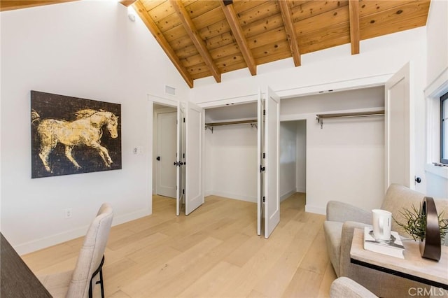 bedroom with multiple closets, light wood-type flooring, wood ceiling, and visible vents