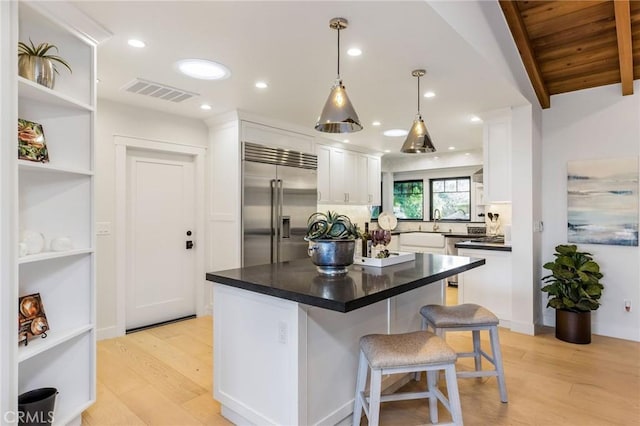 5353 Middlecrest Rd, Rancho Palos Verdes, CA 90275 - kitchen with built in fridge, white cabinets, light wood-type flooring, decorative backsplash, and dark countertops