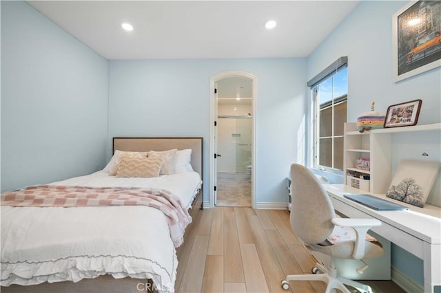 bedroom with connected bathroom, baseboards, wood finished floors, and recessed lighting