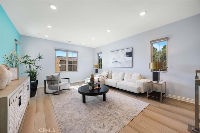 living area with light wood-style floors, recessed lighting, and a healthy amount of sunlight