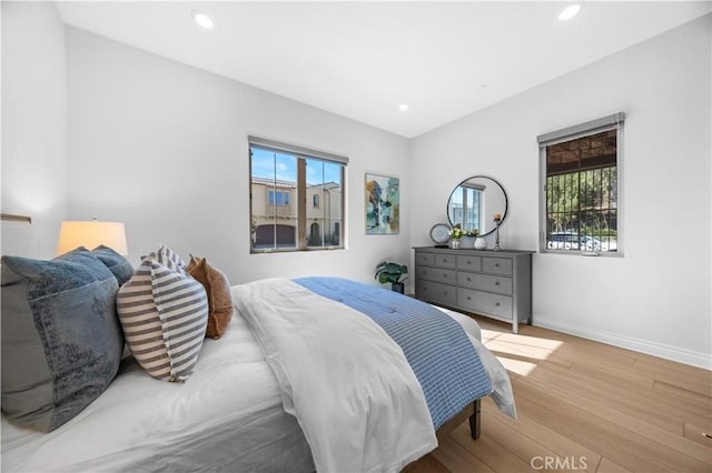 bedroom with recessed lighting, wood finished floors, and baseboards