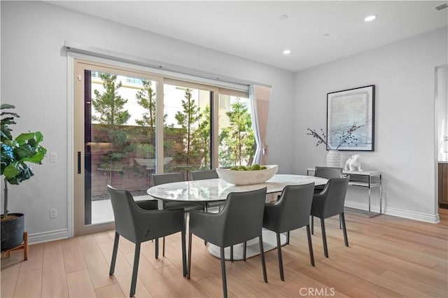 dining space with baseboards, light wood finished floors, visible vents, and recessed lighting