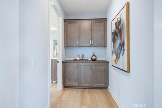 bar featuring baseboards and light wood-style floors