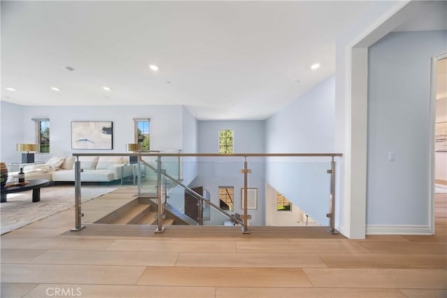 hall with recessed lighting, baseboards, an upstairs landing, and wood finished floors